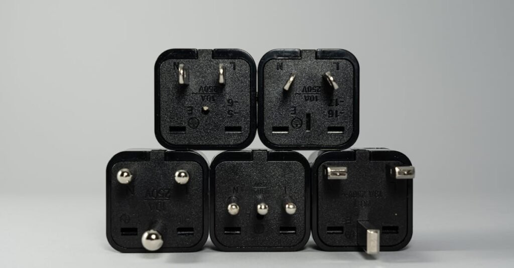 A collection of various black international power plug adapters for global electronics use.